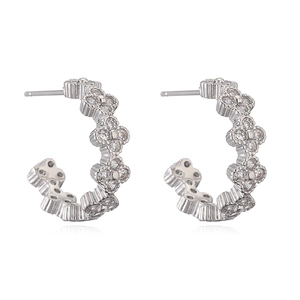 Macro view of silver clover earrings with cubic zirconia and C-shaped design