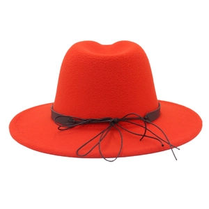 Detail of red wool felt wide brim hat featuring a decorative black drawstring bow