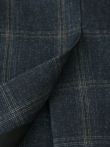 Detailed macro view of high-quality navy blue and brown plaid fabric for blazer