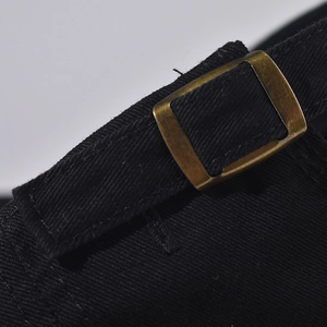 Makroaufnahme der verstellbaren Messingschnalle und schwarzen Baumwoll-Twill-Textur