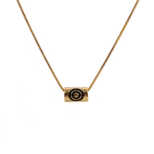 Minimalist gold evil eye necklace with cylindrical pendant on clean white background