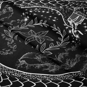 Close-up of black and white bohemian tapestry with mystical stars and leaf patterns