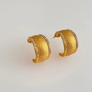Detailed view of gold C-shape hoop earrings with hammered texture and white zircons