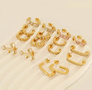 Detailed close-up of 18k gold-plated earrings with shell bow and cubic zirconia stones