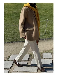 Outdoor street style view of camel suit jacket paired with a vibrant yellow scarf