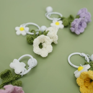 Handmade knitted lily of the valley keychains in purple, cream, yellow and pink wool