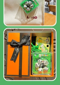 Detail of cute panda fishing toy keychain on bag and gift box with love ribbon