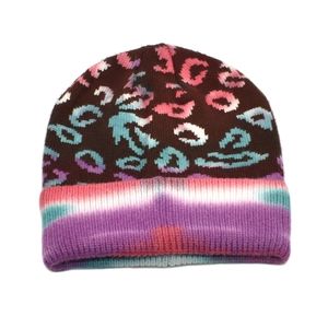 Detail of knitted beanie showing colorful tie-dye brim and leopard print pattern