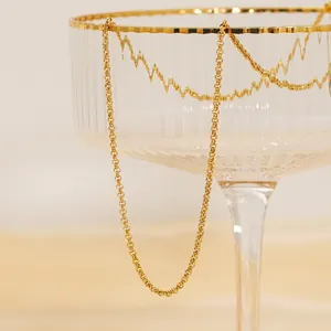 18K gold plated stainless steel cable chain necklace displayed on a textured glass