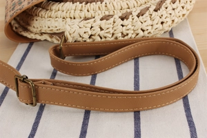 Detailed close-up of woven paper rope texture and brown PU leather strap with stitching