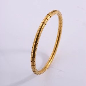 Détail d'un bracelet flexible en acier inoxydable doré avec une texture style bambou segmenté