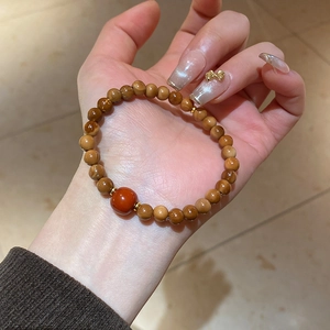 Detail of beaded bracelet with tiger eye stones and golden spacers on a female hand