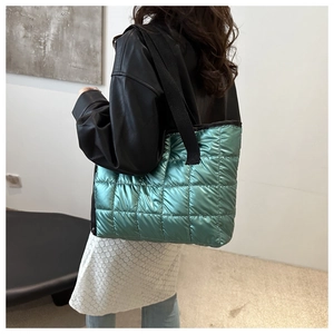 Close-up of green quilted space cotton tote bag with metallic finish and wide strap