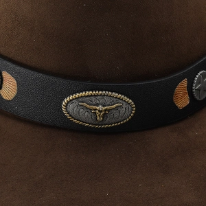 Detailed close-up of brown suede cowboy hat with black leather band and bull skull buckle