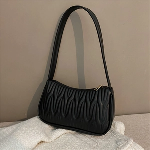 French style mini black shoulder bag with wavy quilted texture on a white towel