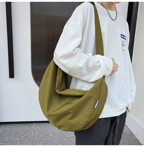 Detail view of olive green crescent oxford crossbody bag on a model side profile