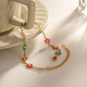 Detail of gold stainless steel bracelet with colorful daisy flowers on ceramic handle