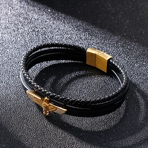 Vue détaillée du bracelet multicouche en cuir noir avec un charme d'aigle doré
