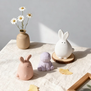 Three minimalist rabbit candle molds in white pink and purple with a matte resin finish