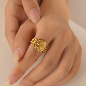 Detailed view of a gold plated titanium steel ring with sun totem and chain texture