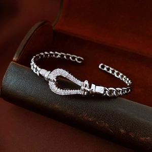 Detail of silver horseshoe buckle bracelet with cubic zirconia on red velvet box
