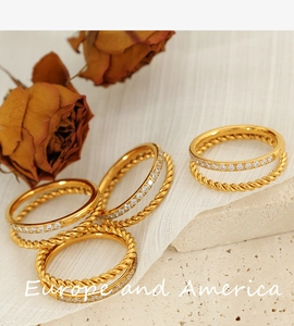 Detail view of gold titanium rings with rhinestones on rustic stone background