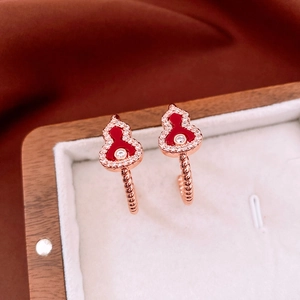 Close-up of rose gold gourd earrings with red enamel and white zircon inlay