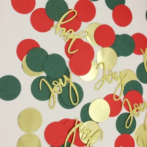Macro shot of Joy confetti and glittery red green gold paper circles for party decor