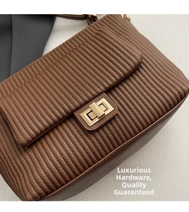 Detailed close-up of brown quilted leather bag with elegant gold rectangular twist lock