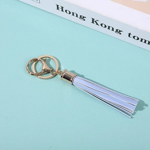 Close-up of light blue PU leather tassel keychain with gold metal clasp and ring detail
