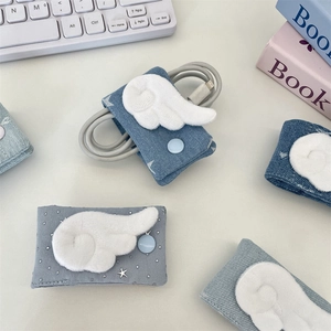 Close-up of denim cable organizers with plush angel wings and snap closure