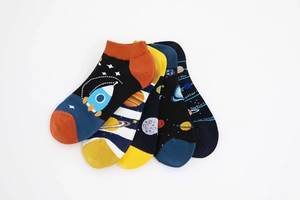 Detail of five pairs of space-themed cotton socks featuring rockets and astronauts