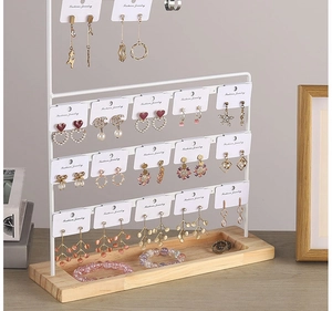 Detail of white metal jewelry rack with 4-tier earring bar and wooden base tray