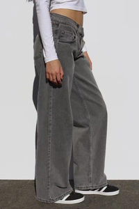 Détail d'un jean taille haute à jambes larges gris foncé délavé avec sergé de denim