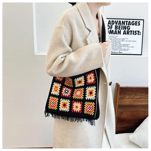 Detail of colorful crochet knit tote bag with fringes shown on a model side view