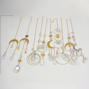 Macro detail of suncatchers with metal celestial symbols and faceted crystal prisms