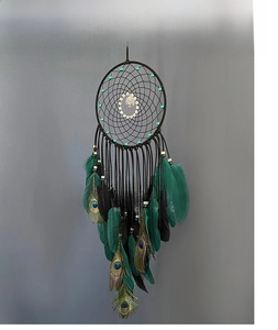 Detail of dream catcher hanging featuring peacock feathers and turquoise beads