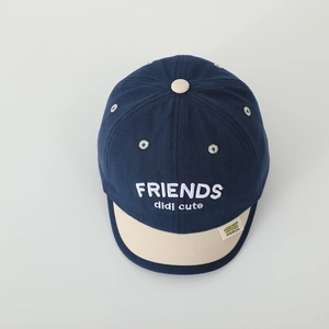 Detail of baby baseball cap with blue crown, beige brim and white FRIENDS embroidery