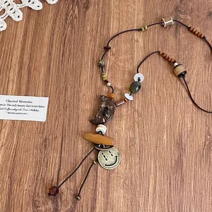 Detail showing bohemian ethnic style necklace with wooden moon, beads and vintage charms