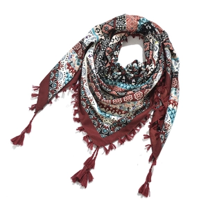 Detailed view of bohemian style jacquard pattern and knotted fringe on a folded scarf