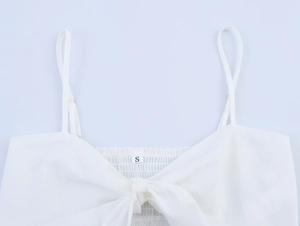 Detail eines weißen Camisole-Tops mit verstellbaren Trägern, Bindeknoten und Smok-Effekt