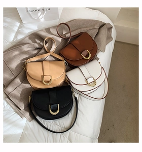 Détail de quatre sacs selle classiques en noir, beige, blanc et marron avec boucles en U dorées