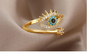 Macro detail of gold evil eye ring with blue beads and shimmering zircon accents