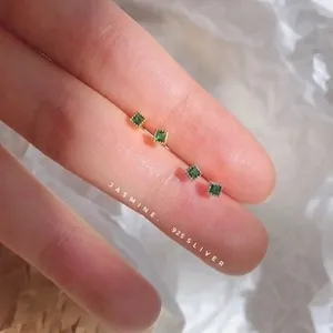 Detail showing 925 silver square earrings with green stones in gold and silver finishes