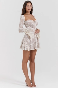 Dettaglio dell'abito in pizzo bianco con scollo a V e maniche a campana eleganti