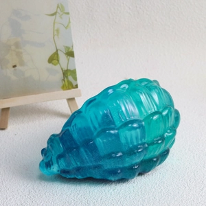 Dettaglio macro del contenitore a conchiglia in resina con gradiente blu e trama a spirale