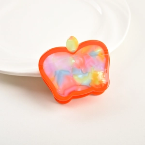 Close-up of apple-shaped hair claw clip with colorful pearlescent acetate finish