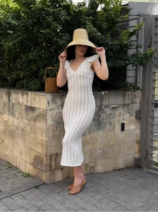 Détail d'une robe longue en dentelle au crochet blanche avec manches à volants style français