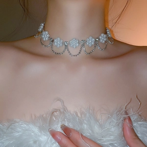Detailed view of floral pearl choker necklace with sparkling rhinestone tassels on model