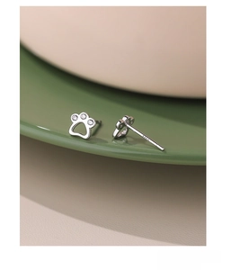 Macro shot of silver cat paw stud earring in S999 silver with zircon stones and hallmark